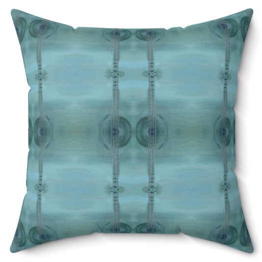A square-shaped throw pillow with a geometric pattern in shades of blue.