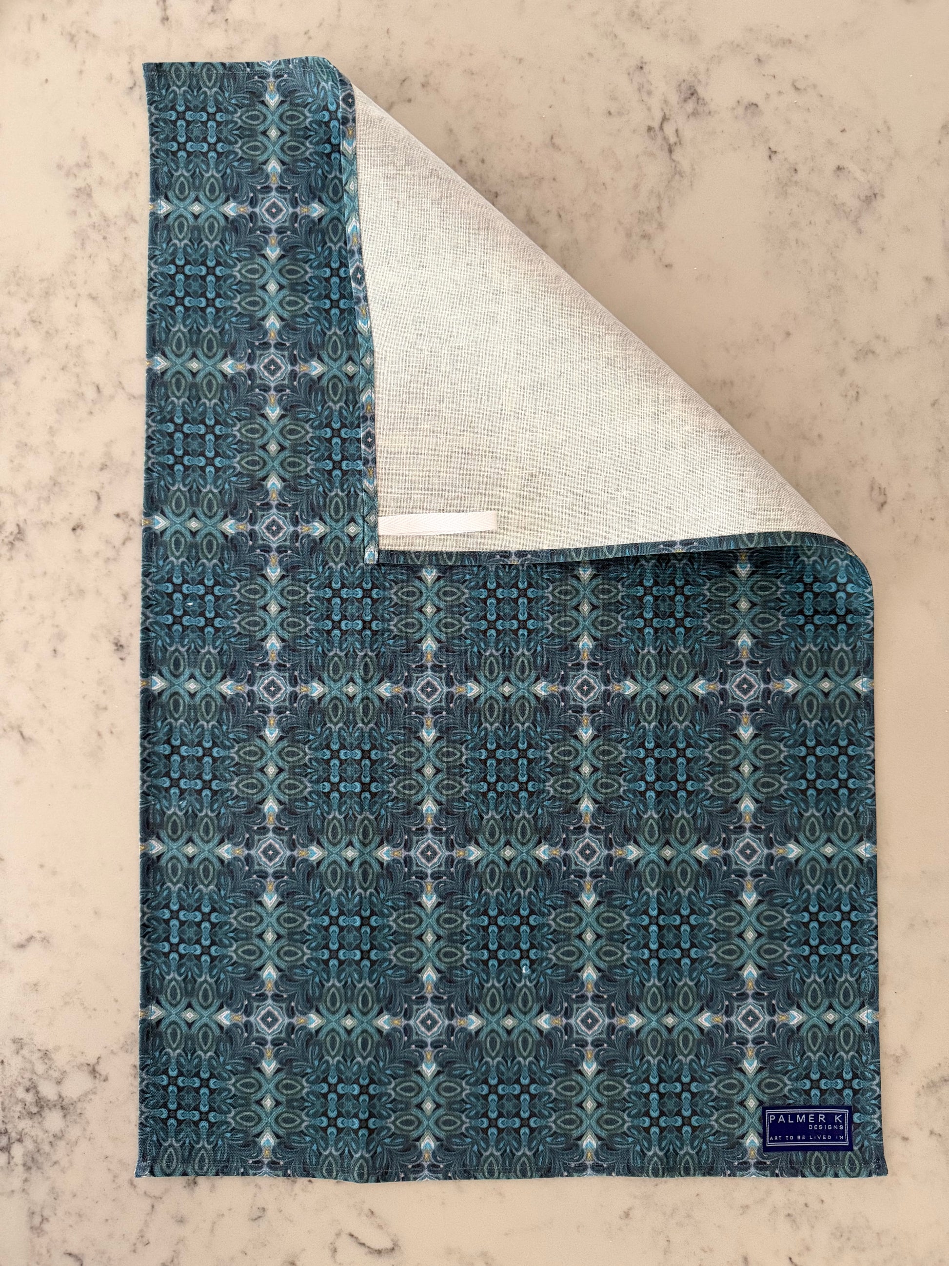 Crafted from 100% French linen woven from premium Normandy flax, each tea towel is printed and sewn in the USA and designed to bring lasting beauty into the kitchen and bath.  Measuring 16x24 inches, the fabric offers the ideal balance of structure and softness - becoming more supple with every wash while maintaining its integrity.

Each pattern begins as an original fine art painting, translated into a layered geometric composition that preserves the movement, texture, and tonal depth of the artwork.  The 