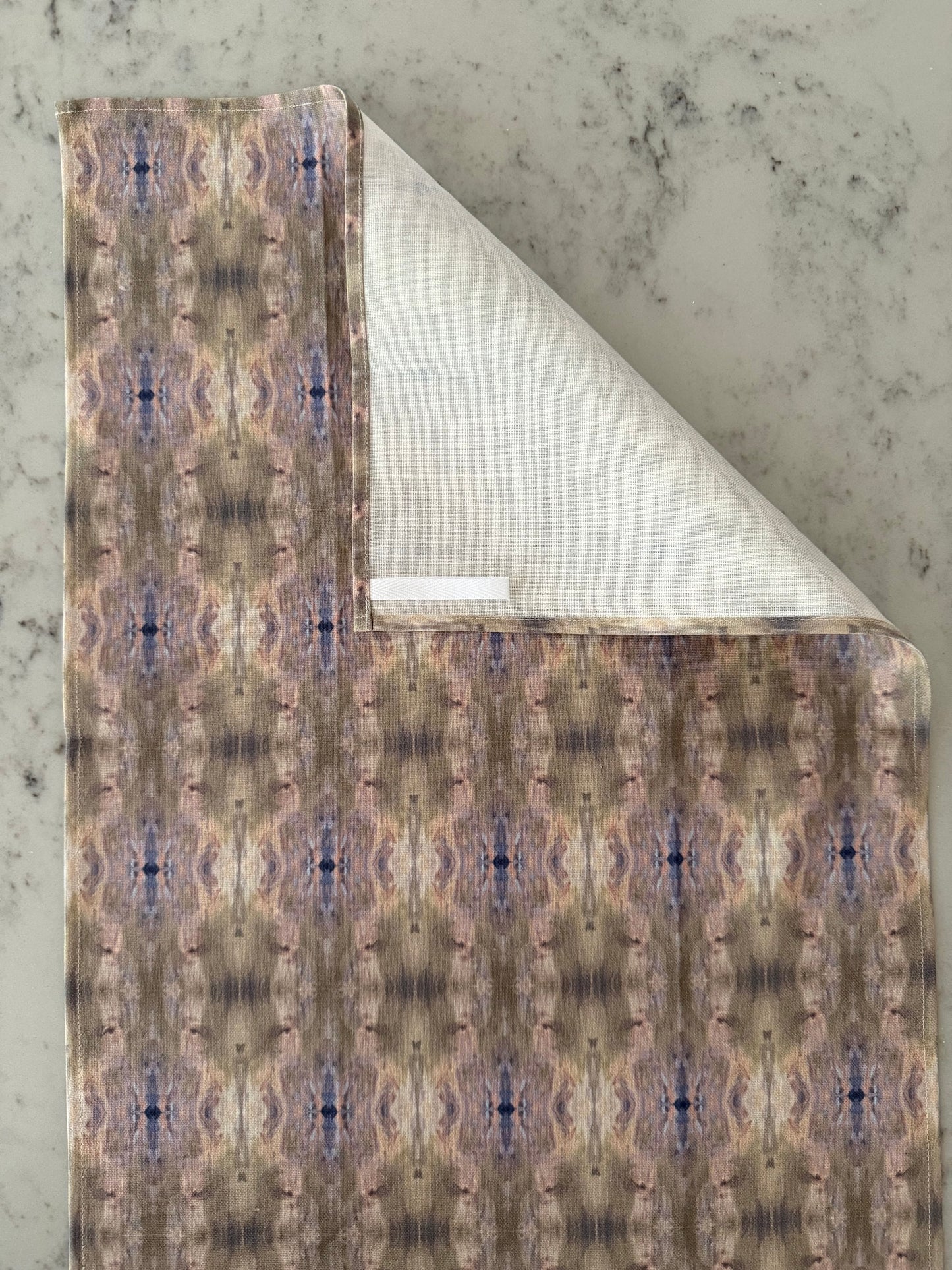 Crafted from 100% French linen woven from premium Normandy flax, each tea towel is printed and sewn in the USA and designed to bring lasting beauty into the kitchen and bath.  Measuring 16x24 inches, the fabric offers the ideal balance of structure and softness - becoming more supple with every wash while maintaining its integrity.

Each pattern begins as an original fine art painting, translated into a layered geometric composition that preserves the movement, texture, and tonal depth of the artwork.  The 