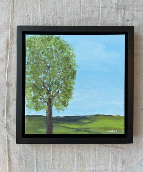painting of single green leafed tree in field with horizon and blue sky 12 x 12 acrylic on gallery wrap canvas in black wood float frame Signed on front, titled on back D rings and wire on back ready to hang &nbsp; All palmer K designs artwork © Karen Palmer. &nbsp;All rights reserved.